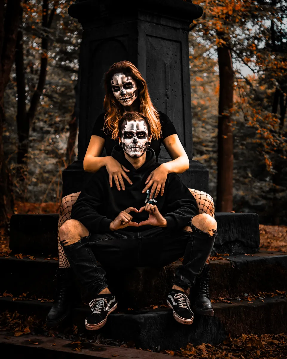 Paar mit Totenkopf-Make-up im Herbstwald