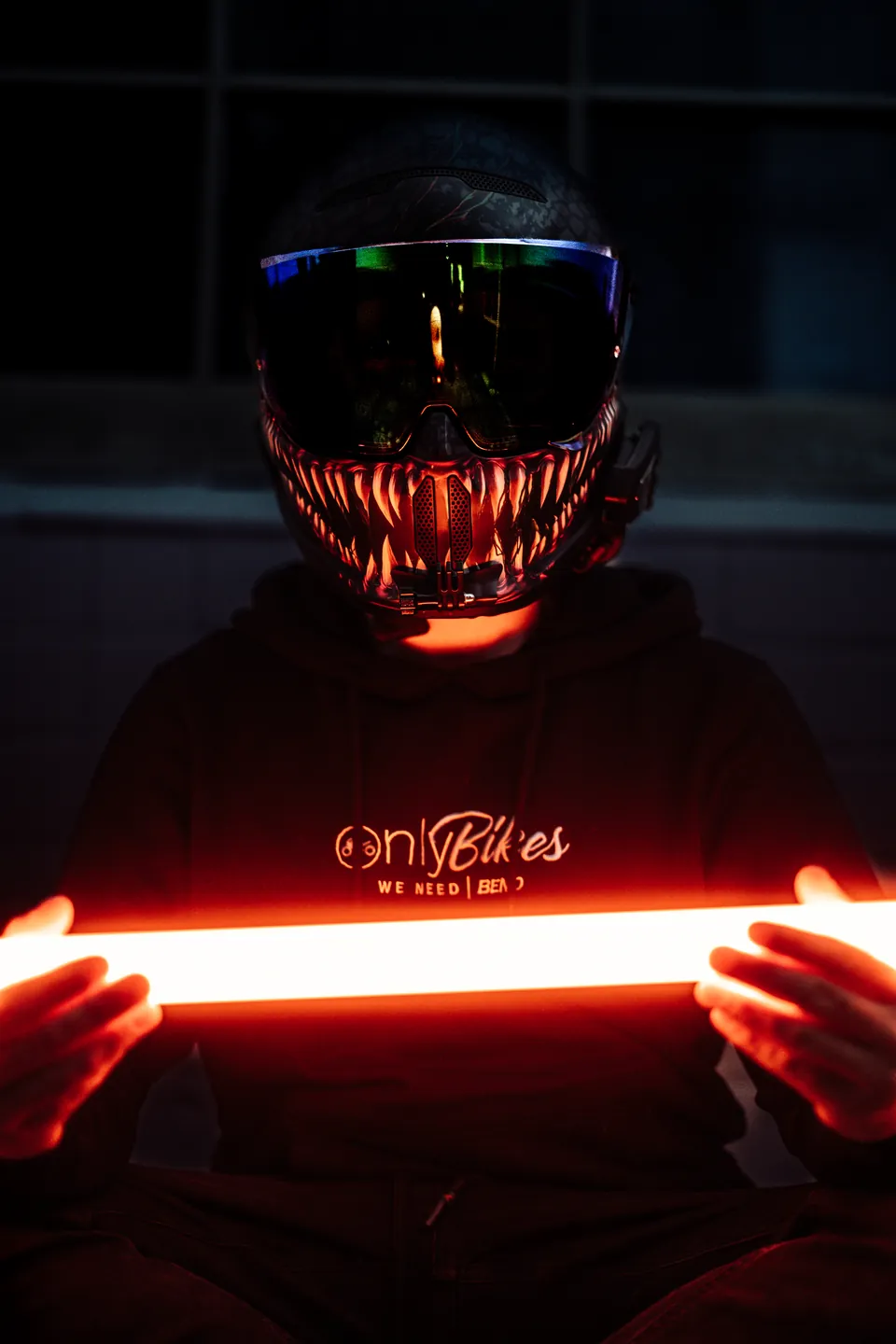 Helm mit leuchtendem Visier und LED-Röhre in der Dunkelheit