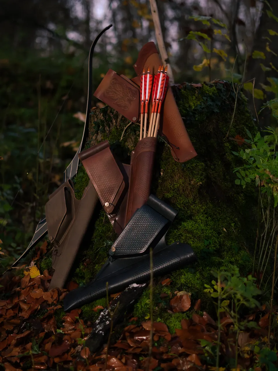 Leder-Köcher und Pfeile auf Moos im Wald