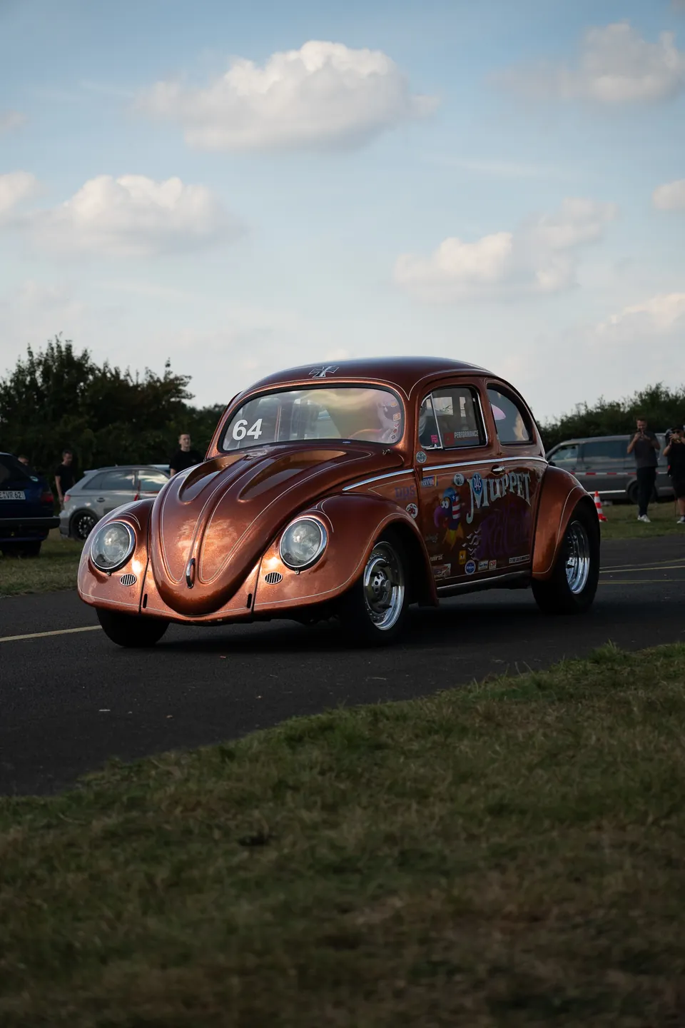 Kupferfarbener VW Käfer auf einem Parkplatz