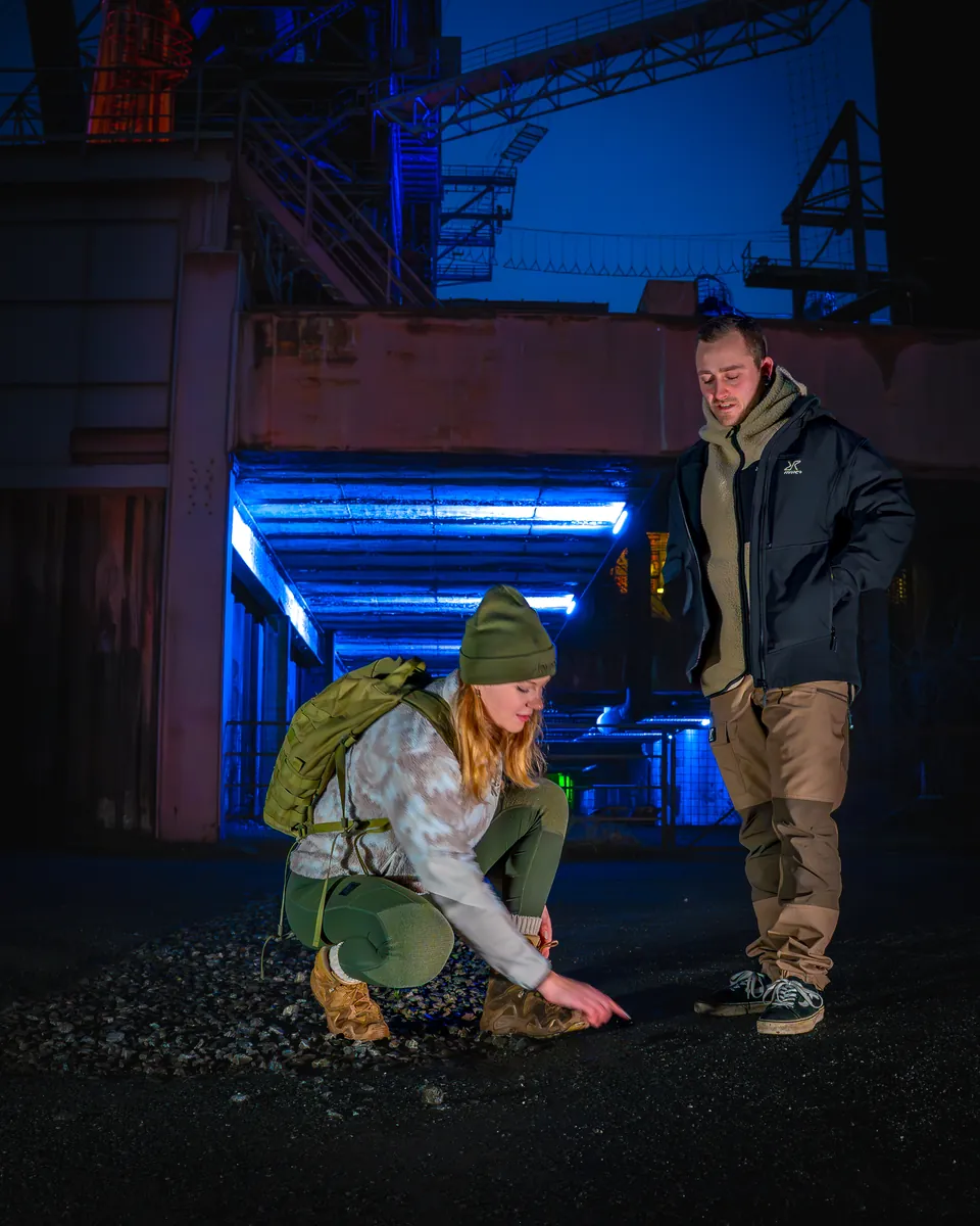 Zwei Personen in blauem Licht in einer Industriehalle