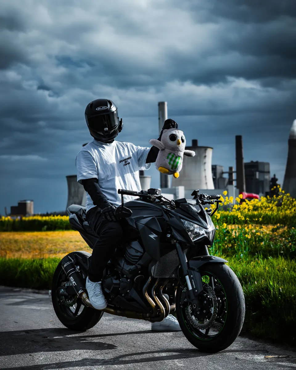 Fahrer auf einem Naked Bike vor Kraftwerk und Gewitterhimmel